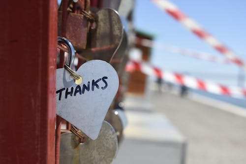 Free A heart-shaped love lock with 'THANKS' inscribed, hanging on a fence, symbolizing gratitude. Stock Photo